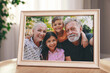 © New Africa - Framed family photo on wooden table in room