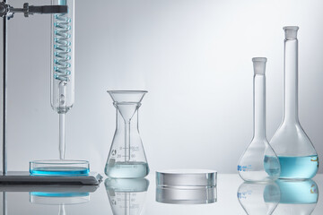 
Assorted laboratory glassware equipment showcase with blue water on white backround. Stage showcase cosmetics on glass pedestal modern in laboratory equipment. 
