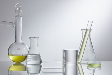 Laboratory glass equipment with yellow water ingredients on white background. Research and development cosmetics concept. Stage showcase cosmetics on glass pedestal modern in laboratory equipment.