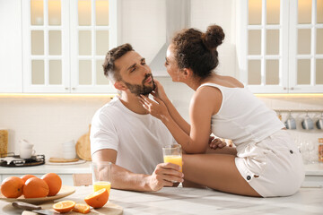 Poster - Lovely couple enjoying time together during breakfast at table in kitchen