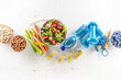 © weyo - Healthy fresh salad with tomatoes surrounded with exercise equipment, carrtot celery and measuring tape - top of view