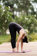 © EduLife Photos - A confident middle-aged Asian woman in sports outfit doing yoga exercise on the yoga mat outdoor in the backyard in the morning. Young woman doing yoga exercise outdoor in the nature public park
