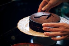 Cropped Hand Of Man Holding Chocolate Cake