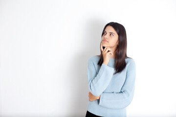 Portrait of a brooding teenage girl with dark hair in a blue blouse. White background, space for text.