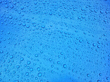 Close-up Of Water Drops On Blue Glass