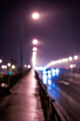 Wall Mural - The bright lights of the city at night, busy traffic on the road bridge. Defocused image