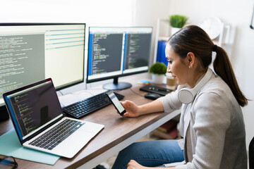 Beautiful woman programming on her smartphone