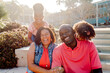 © Erin Brant/Stocksy - Happy family on steps in sunshine