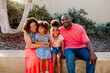 © Erin Brant/Stocksy - Happy family sitting together outdoors