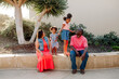 © Erin Brant/Stocksy - Girls on ledge between seated parents