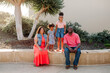 © Erin Brant/Stocksy - Smiling parents and two daughters outside