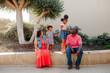 © Erin Brant/Stocksy - Sisters standing between seated parents
