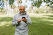 © McKinsey Jordan/Stocksy - Older Man Takes a Break From Workout to Look at Phone