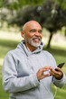 © McKinsey Jordan/Stocksy - Senior Man Smiles While Listening to Headphones in Park