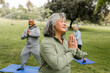 © McKinsey Jordan/Stocksy - Older Woman Enjoys Stretching at Group Yoga in the Park