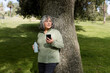 © McKinsey Jordan/Stocksy - Senior Woman in Park Holds Phone and Water Bottle