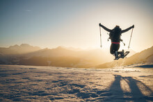 Joyful Girl Jumps In Front Of Winterly Alps Landscape.