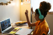 © BONNINSTUDIO/Stocksy - Schoolgirl having online lesson with laptop at home