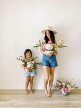 Mom And Daughter Holding Flower Bouquets