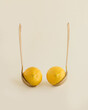 © jbuinac - Provocative arrangement with couple of lemons in gold luxurious ladles, isolated on pastel beige background. Woman’s breast in golden bra minimal concept. Food, kitchen, aphrodisiacs and sexuality.