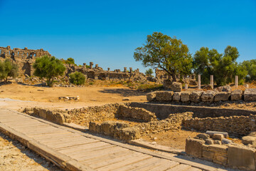 Wall Mural - SIDE, TURKEY: Ancient ruins and a road in the city of Side on a sunny summer day.