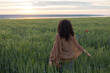 © Demetr White/Stocksy - a girl walking in a green wheat field
