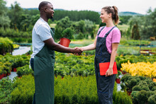 Man And Woman Shaking Hands In Greenhouse 
