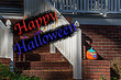 Happy Halloween text card, on a facade with pumpkins background