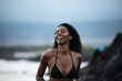 © David Prado/Stocksy - Woman in bikini in a volcanic beach