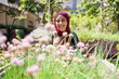 © Studio Marmellata/Stocksy - Cheerful Muslim woman cultivating allium in garden