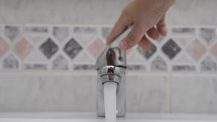 Poster - A hand turning on and off the tap for running water in HD