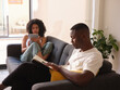 © Miquel Llonch/Stocksy - Black couple reading home.