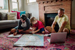 © Erin Brant/Stocksy - Brothers study map with help from dad