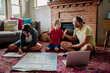 © Erin Brant/Stocksy - Dad talking with sons while planning trip
