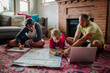 © Erin Brant/Stocksy - Dad helping sons with map