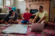 © Erin Brant/Stocksy - Happy dad and boys planning trip