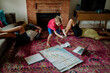© Erin Brant/Stocksy - Boy leans over map while planning trip
