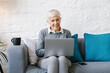 © Mihajlo Ckovric/Stocksy - Senior businesswoman sitting at the couch in the office using her laptop