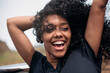 © David Prado/Stocksy - Happy ethnic female with curly hair