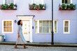 © David Prado/Stocksy - Woman walking by beautiful multicolored houses facades