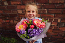 Child Holding A Large Bunch Of Peony Flowers