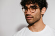 © BONNINSTUDIO/Stocksy - Serious Hispanic man in glasses