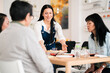 © Studio Marmellata/Stocksy - Smiling woman serving food for Asian friends