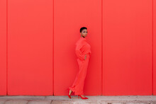 Beautiful Female With Electric Red Suit Against Red Wall