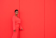 Beautiful Female With Electric Red Suit Against Red Wall