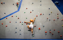 Girl Climbing On An Indoor Rock Wall