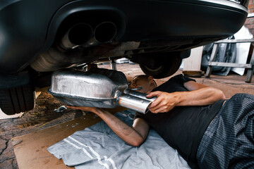 Wall Mural - An auto mechanic works in a garage. Car repair