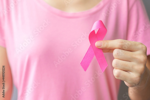 October Breast Cancer Awareness month, elderly Woman in pink T- shirt with hand holding Pink Ribbon for supporting people living and illness. International Women, Mother and World cancer day concept