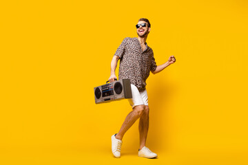 Sticker - Full length photo of charming pretty young guy wear leopard outfit dark eyewear holding boom box isolated yellow color background