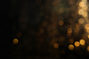 Wall Mural - blurred view of golden lights on black background. bokeh effect